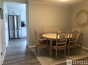 Anacortes apartment for rent - A kitchen with a refrigerator and a dining table with chairs.