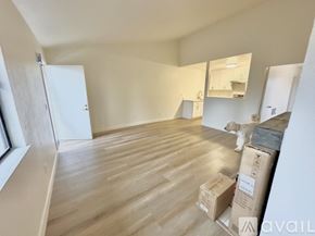 Oakland apartment for rent - A room with wooden flooring and boxes scattered around.