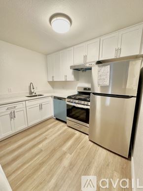 Oakland apartment for rent - A kitchen with white cabinets and a wooden floor.