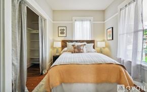 Oakland apartment for rent - A bedroom with a large bed and a window with curtains.