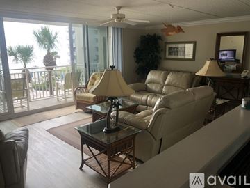 New Smyrna Beach condo for rent - A living room with a glass table and a sofa.