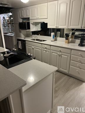 New Smyrna Beach condo for rent - A kitchen with white cabinets and a granite counter.