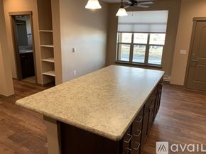 Helena apartment for rent - A spacious room with a large table and a ceiling fan.