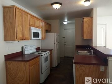 Fort Worth apartment for rent - A kitchen with wooden cabinets and white appliances.