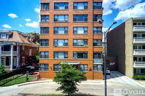 Chicago apartment for rent - A tall red brick building with a balcony on the top floor.