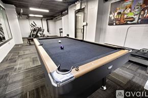 Chicago apartment for rent - A pool table in a room with a painting on the wall.