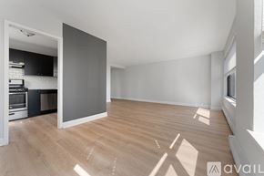 Chicago apartment for rent - A spacious room with wooden flooring and a large grey wall.