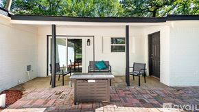 Lake Worth house for rent - A white house with a brick patio and a black table and chairs.