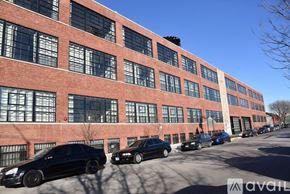 Chicago apartment for rent - A row of cars parked in front of a red brick building.
