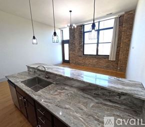 Chicago apartment for rent - A kitchen with a marble countertop and pendant lights.