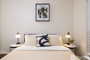 Euless house for rent - A bedroom with a bed, two lamps, and a framed picture on the wall.