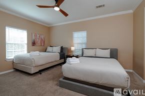 Dallas house for rent - A bedroom with two beds and a ceiling fan.