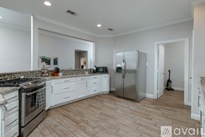 Dallas house for rent - A kitchen with a stove top oven and a refrigerator.
