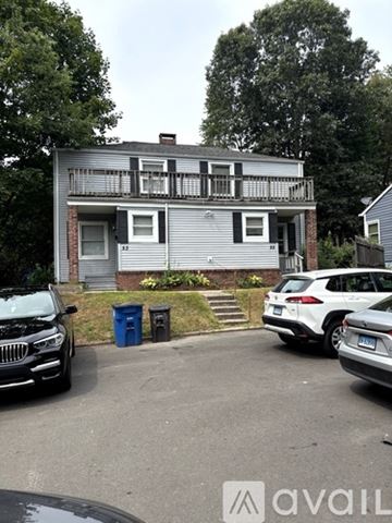 New Haven apartment for rent - A two-story house with a balcony and a car parked in front.