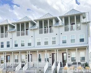 South Jordan townhouse for rent - A serene landscape with a lake, houses, and a clear sky.