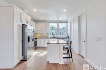 South Jordan townhouse for rent - A modern kitchen with white cabinets and a wooden island.