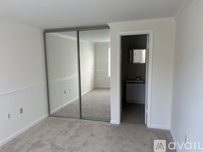 Alexandria condo for rent - A room with a carpeted floor and a sliding glass door leading to another room.