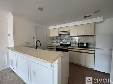 Alexandria condo for rent - A kitchen with white cabinets and appliances.