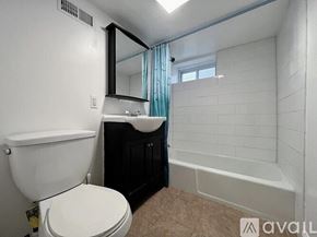 Revere apartment for rent - A bathroom with a white toilet, a sink, and a bathtub.