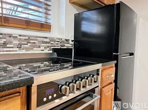 Revere apartment for rent - A black refrigerator sits next to a stove in a kitchen.
