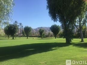 Rancho Mirage condo for rent - A grassy field with trees and mountains in the distance.