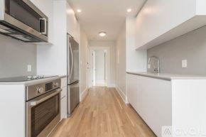 Boston apartment for rent - A modern kitchen with stainless steel appliances and wooden floors.