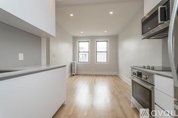 Boston apartment for rent - A kitchen with white cabinets and a wooden floor.