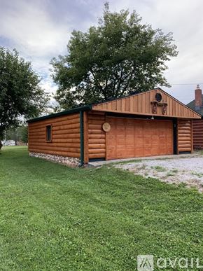 Indianapolis house for rent - A wooden building with a green roof and a brown garage door.