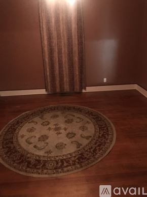 Indianapolis house for rent - A brown carpet with a circular design is on a wooden floor.