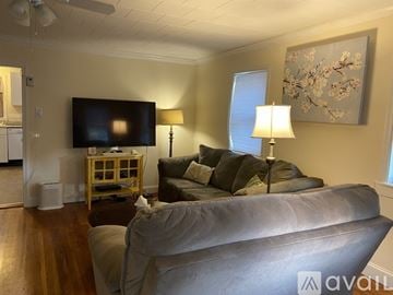 Collegeville house for rent - A living room with a grey couch and a television on the wall.