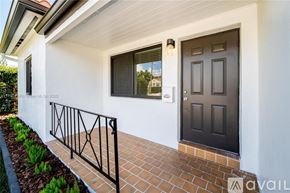 Miami house for rent - A white house with a black door and window.