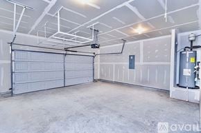 Greer house for rent - A spacious garage with a closed white door and a grey floor.