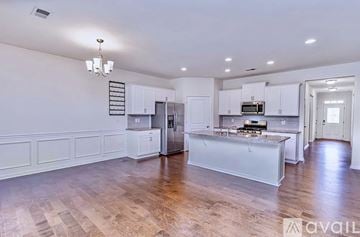 Greer house for rent - A kitchen with white cabinets and a wooden floor.