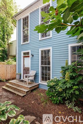 Charlottesville townhouse for rent - A living room with a staircase and a red chair.