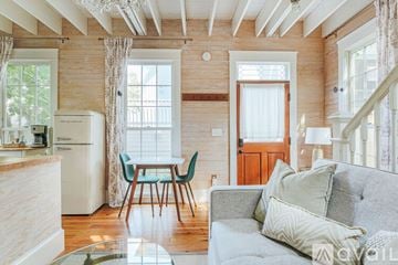 Charlottesville townhouse for rent - A living room with a grey couch and a dining table with chairs.