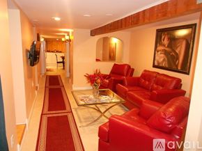 Niagara Falls apartment for rent - A hallway with red couches and a painting on the wall.