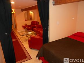 Niagara Falls apartment for rent - A bedroom with a red couch and a brown bed.