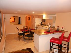 Niagara Falls apartment for rent - A kitchen with a table and chairs in the middle.