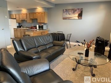 Niagara Falls apartment for rent - A black leather sofa and chairs in a living room.