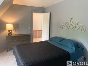 Niagara Falls apartment for rent - A bedroom with a bed, dresser, and lamp.