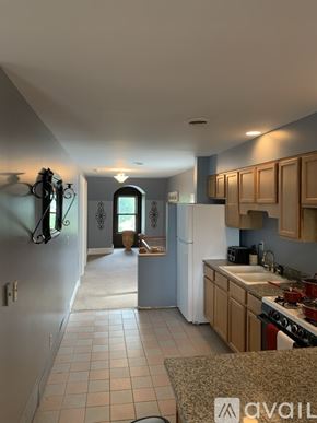 Niagara Falls apartment for rent - A kitchen with a white refrigerator and wooden cabinets.