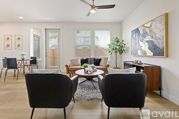 Boise townhouse for rent - A living room with a black chair in the foreground and a painting on the wall.