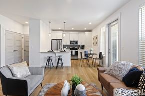 Boise townhouse for rent - A modern living room with a kitchen in the background.