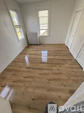 Marshalltown apartment for rent - A room with wooden flooring and white walls, with a window and a radiator.