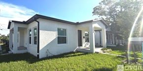 St Petersburg townhouse for rent - A white house with a black roof is surrounded by green grass.