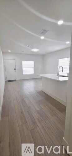 St Petersburg townhouse for rent - A spacious room with wooden flooring and white walls.