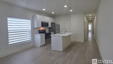 St Petersburg townhouse for rent - A modern kitchen with white cabinets and a wooden floor.