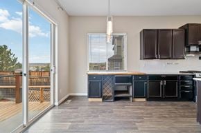 Parker house for rent - A kitchen with dark brown cabinets and a wooden floor.