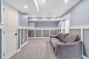 Parker house for rent - A spacious living room with a grey sofa and a grey carpet.