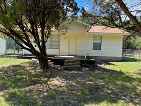 Morgan's Point Resort house for rent - A small white house with a tree in front.